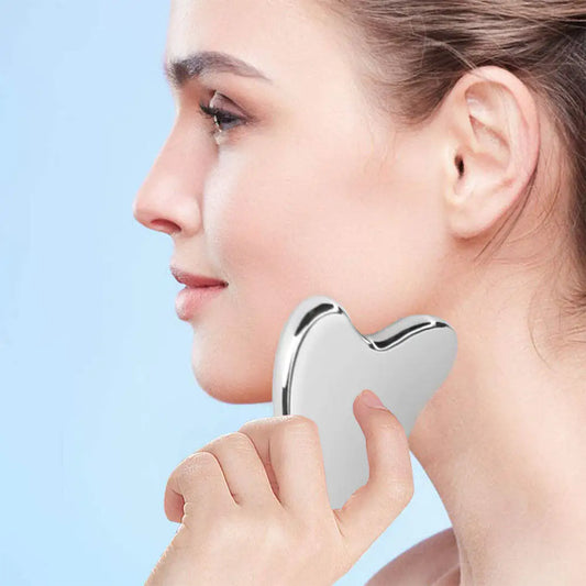 stainless steel gua sha on a lady's face